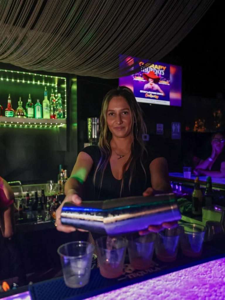 Bartender serving a tray of drinks at the Controversy Pittsburgh bar
