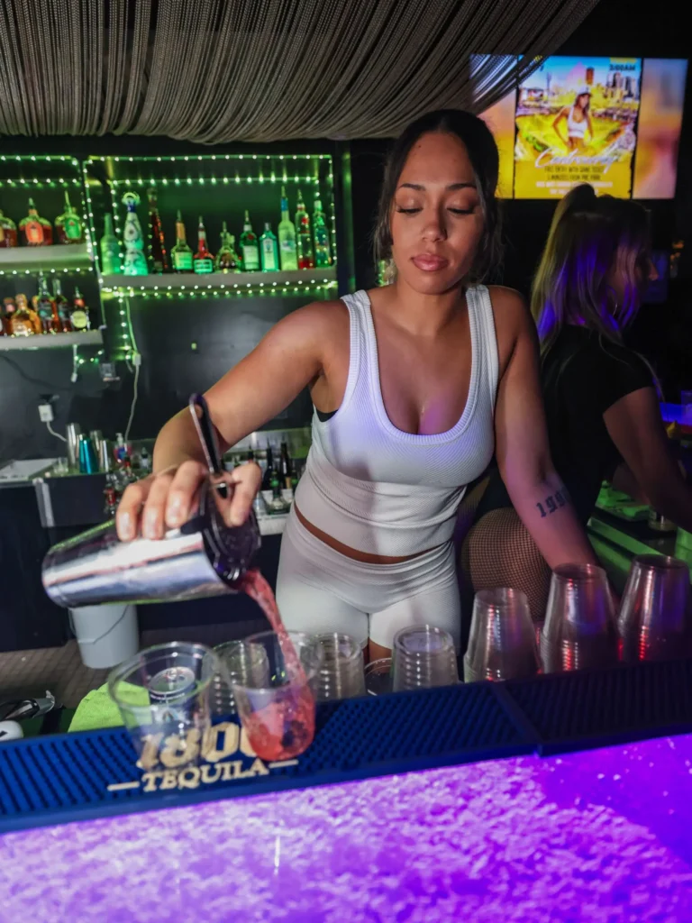 Bartender mixing cocktails behind the bar at Controversy Pittsburgh nightclub
